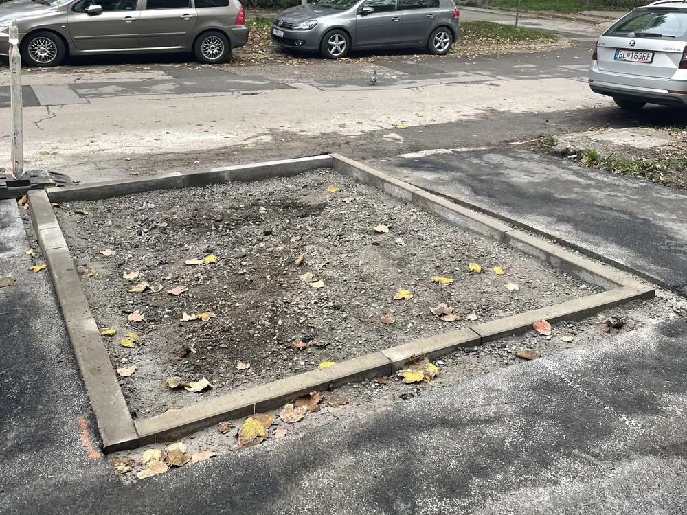 Holý výrez v asfalte medzi parkovaním pred premenou
